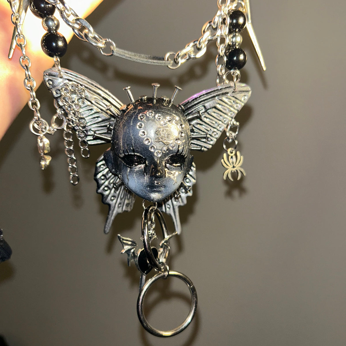 Silver Metallic Butterfly Doll Face Necklace with Rhinestone Heart & Winged Skull Charm product image 1