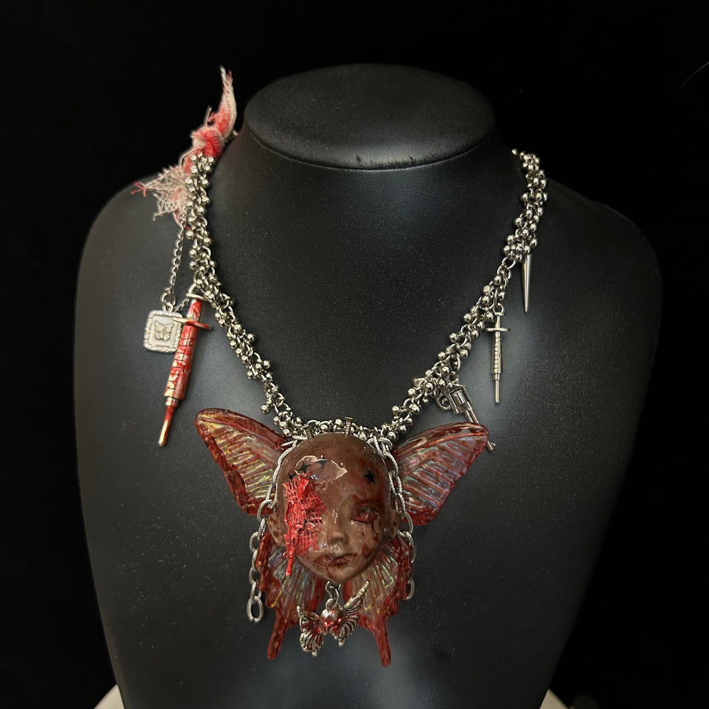 Menhera Bloody Injured Doll Face Necklace with Syringe & Revolver Charms - R - Crux Jewelry product photo