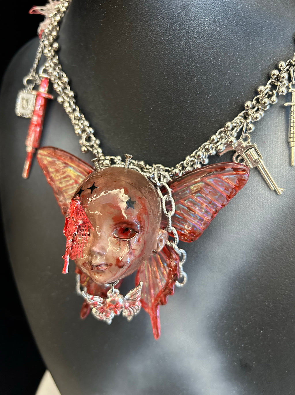 Menhera Bloody Injured Doll Face Necklace with Syringe & Revolver Charms - R - Crux Jewelry product photo